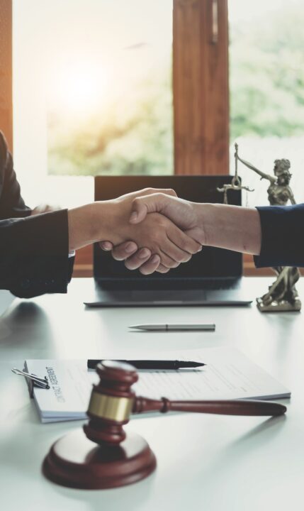 Businessman shaking hands to seal a deal with his partner lawyers or attorneys discussing a contract